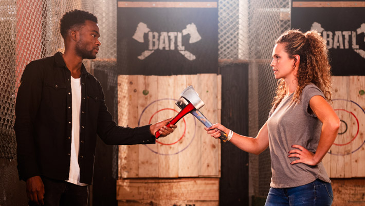 Image of two people clinking before a casual axe throwing match with BATL Targets behind them. Experience the thrill of the bullseye today.